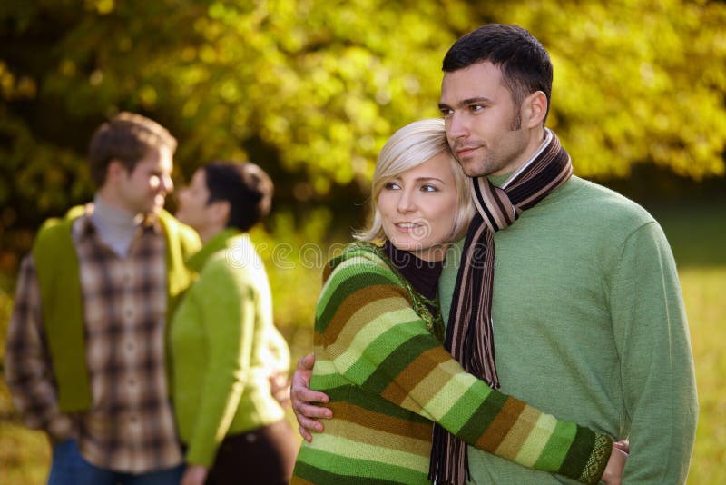 Young love couples hugging and walking in park outdoor at autumn, smiling. Young love couples hugging and walking in park outdoor at autumn, smiling.