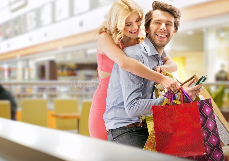 Jeunes couples gais dans le centre commercial images stock Jeunes couples gais dans le centre commercial images stock