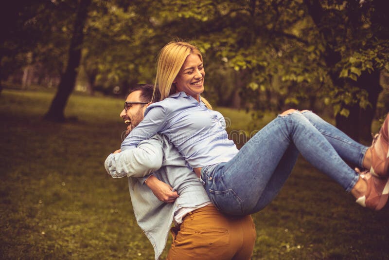 Jeunes couples heureux en stationnement photographie stock libre de droits Jeunes couples heureux en stationnement photographie stock libre de droits