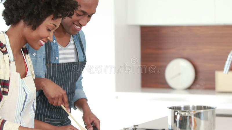 Jeunes couples heureux faisant cuire ensemble banque de vidéos