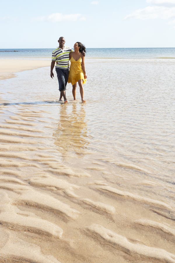 Jeunes couples marchant le long de la fixation H de rivage images stock Jeunes couples marchant le long de la fixation H de rivage images stock