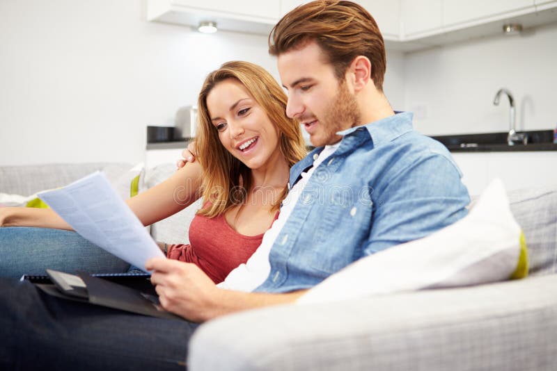 Jeunes couples regardant par des finances personnelles à la maison