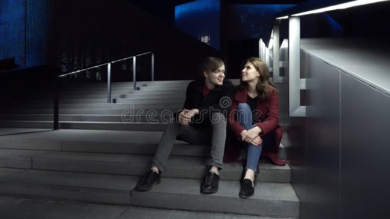 Jeunes couples se reposant sur des escaliers la nuit Belle nuit pour une promenade autour de la ville photos stock Jeunes couples se reposant sur des escaliers la nuit Belle nuit pour une promenade autour de la ville photos stock