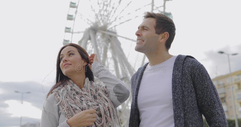 Jeunes couples se tenant devant une roue de ferris clips vidéos