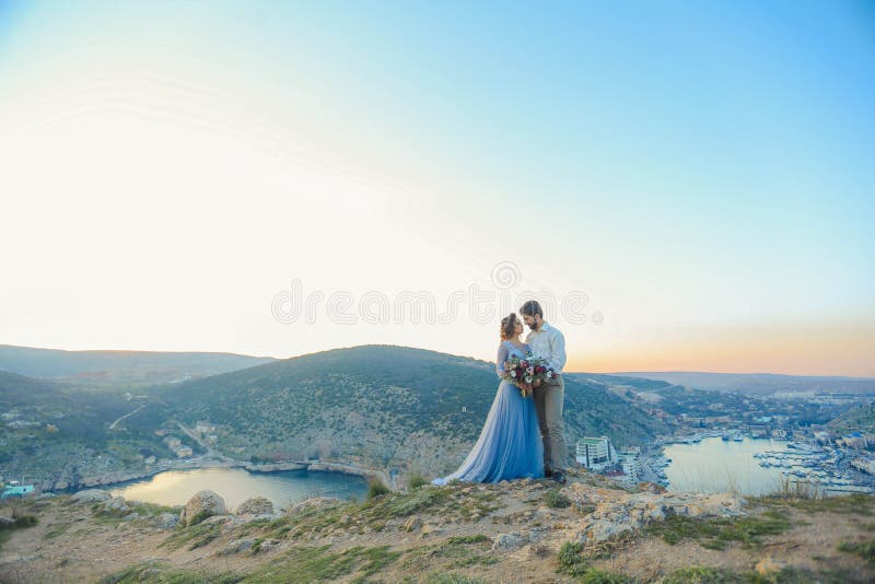 Jeunes couples sensuels dans l'amour se tenant sur la roche en mer près de la plage avec de grandes falaises Mains de fixation d' images stock Jeunes couples sensuels dans l'amour se tenant sur la roche en mer près de la plage avec de grandes falaises Mains de fixation d' images stock