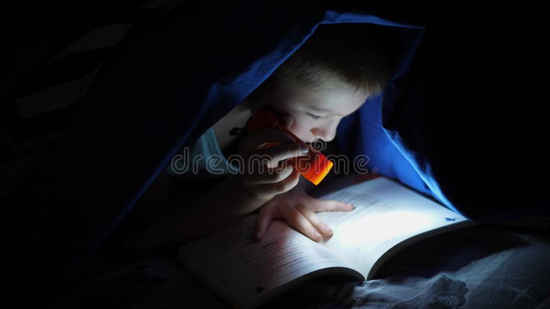 Jeunes enfants à lire un livre caché sous les dessus de lit