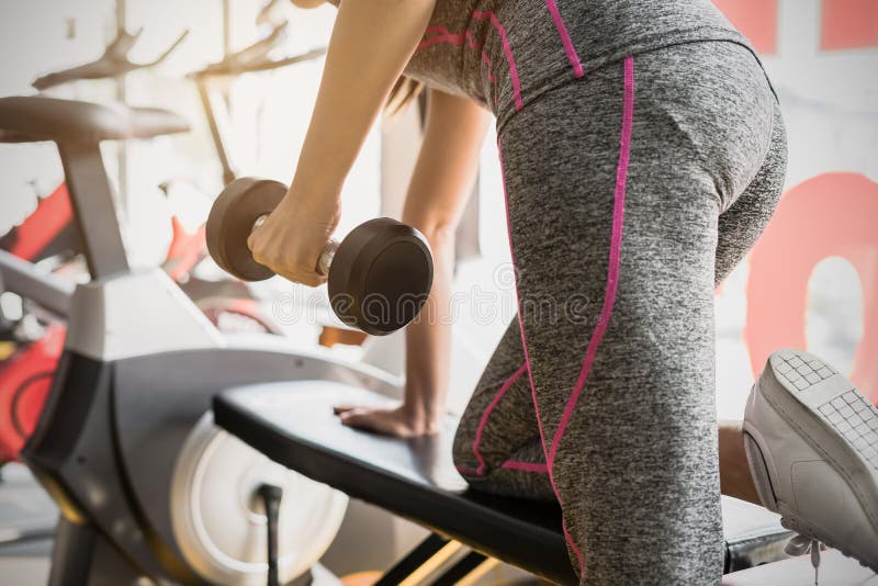 Jeunes femmes asiatiques soulevant l'haltère dans le gymnase de sport photographie stock libre de droits Jeunes femmes asiatiques soulevant l'haltère dans le gymnase de sport photographie stock libre de droits