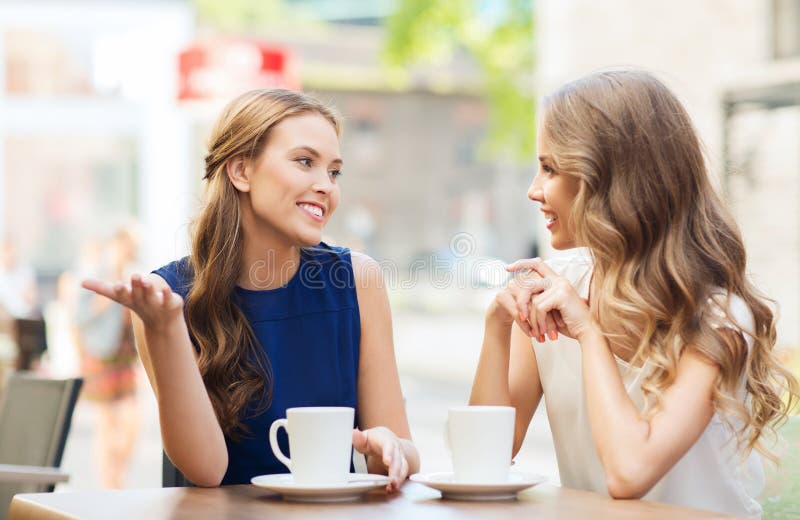 Jeunes femmes buvant du café et parlant au café