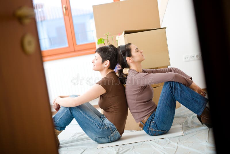 Jeunes femmes déménageant à la maison photo stock Jeunes femmes déménageant à la maison photo stock