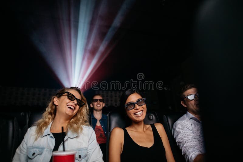 Young women watching 3d movie in cinema. People in theater with 3d glasses. Young women watching 3d movie in cinema. People in theater with 3d glasses.