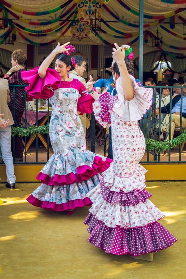 Jeunes femmes portant des robes de flamenco et dansant “Sevillanas chez April Fair, Séville Feria de Sevilla juste image stock Jeunes femmes portant des robes de flamenco et dansant “Sevillanas chez April Fair, Séville Feria de Sevilla juste image stock