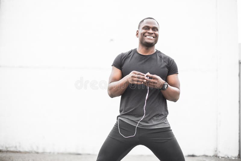 Jeunes formation et faire masculins de sourire d'athlète de taqueur l'extérieur de séance d'entraînement dans la ville un homme d photographie stock libre de droits Jeunes formation et faire masculins de sourire d'athlète de taqueur l'extérieur de séance d'entraînement dans la ville un homme d photographie stock libre de droits