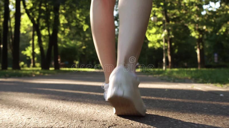 Jeunes jambes femelles marchant en parc