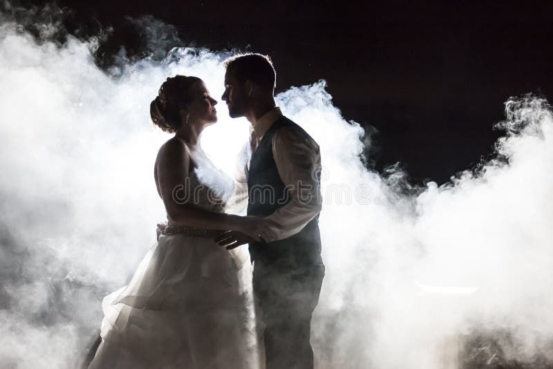 Jeunes mariés en brouillard la nuit image stock