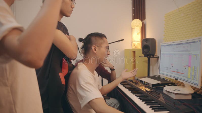 Jeunes musiciens asiatiques travaillant ensemble éditant la musique