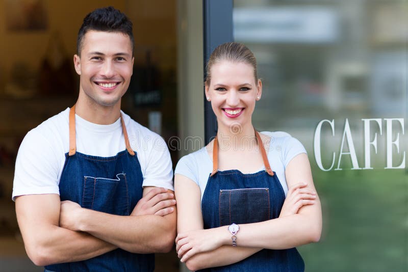 Jeunes propriétaires de café en porte images libres de droits Jeunes propriétaires de café en porte images libres de droits