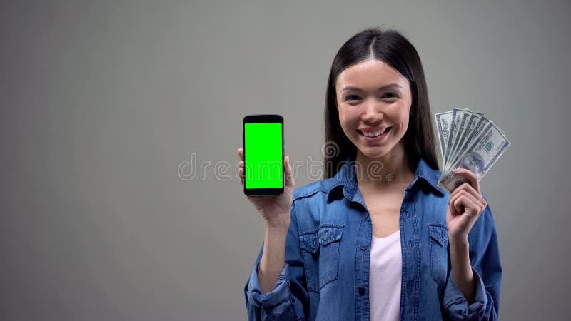 Jeunes smartphone de participation de femme et dollars asiatiques, d?veloppement d'applications informatique image stock Jeunes smartphone de participation de femme et dollars asiatiques, d?veloppement d'applications informatique image stock