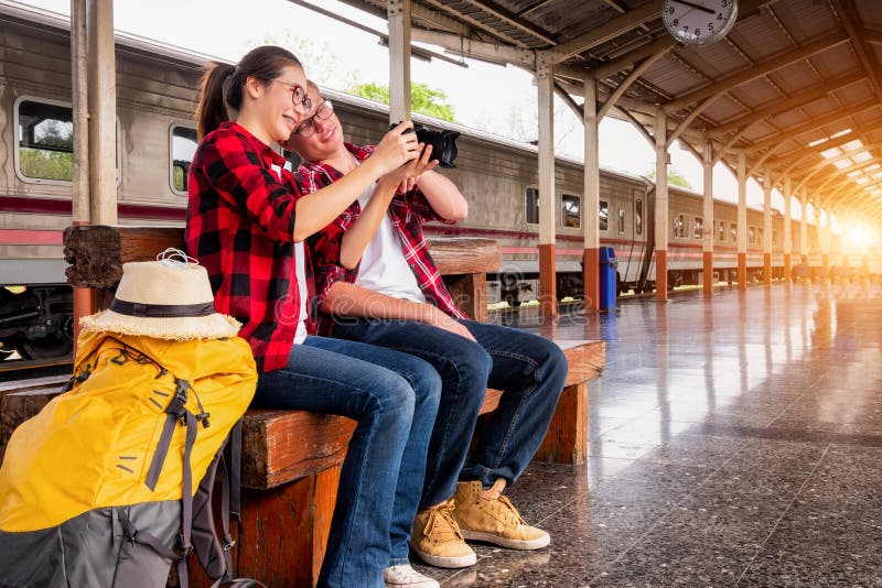 Jeunes voyageurs heureux de couples ensemble des vacances prenant une photo à la station de train, concept de voyage, concept de photo libre de droits Jeunes voyageurs heureux de couples ensemble des vacances prenant une photo à la station de train, concept de voyage, concept de photo libre de droits