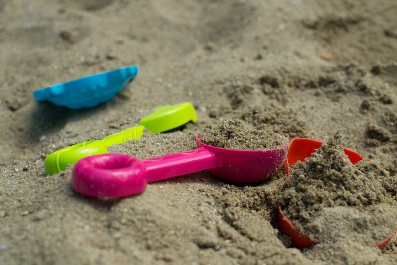 Jeux d'été dans le bac à sable avec les jouets colorés photo stock Jeux d'été dans le bac à sable avec les jouets colorés photo stock