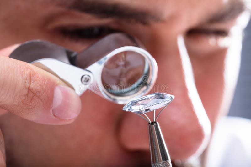 Jeweler Looking At Diamond Through Magnifying Loupe