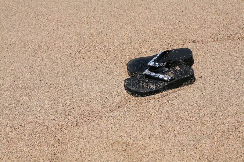 Jewelled dirty sandals in the sand