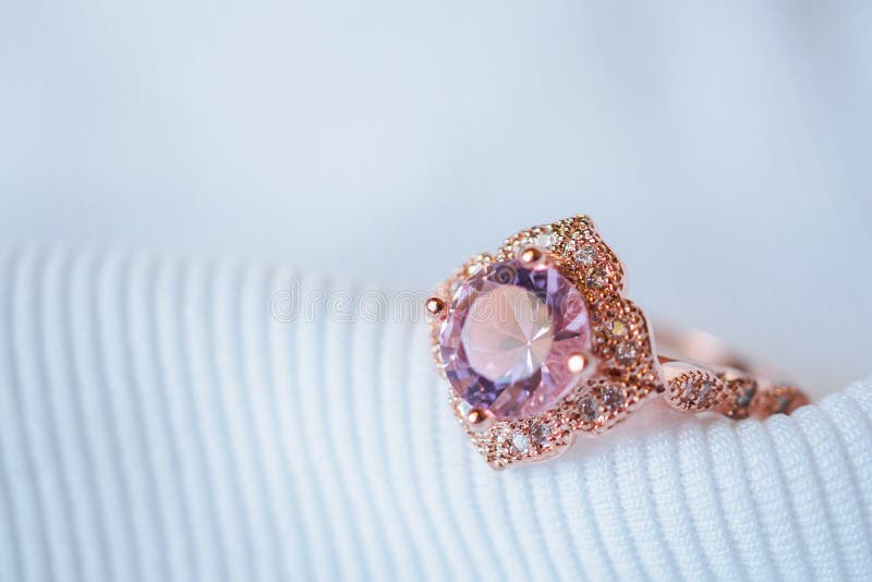 Jewelry luxury pink gold sapphire gemstone ring on white fabric background. Jewelry luxury pink gold sapphire gemstone ring on white fabric background