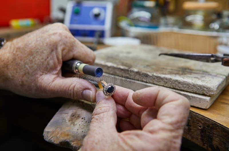 Jewelry production. Jeweler polishes a gold ring royalty free stock photo Jewelry production. Jeweler polishes a gold ring royalty free stock photo