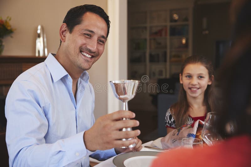 Jewish man holding kiddish cup blesses family at Shabbat royalty free stock image Jewish man holding kiddish cup blesses family at Shabbat royalty free stock image