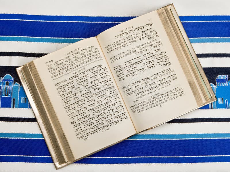 A Jewish prayer book, or Siddur, open and on top of a Jewish prayer shawl, or Tallit. A Jewish prayer book, or Siddur, open and on top of a Jewish prayer shawl, or Tallit.