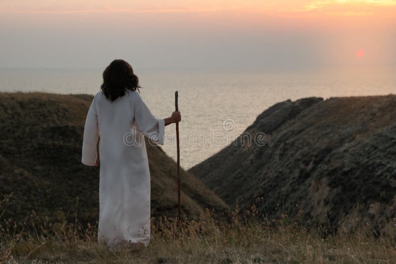 Jezus christ z patykiem na wzgórzach na zachodzie słońca. spacja dla tekstu fotografia stock