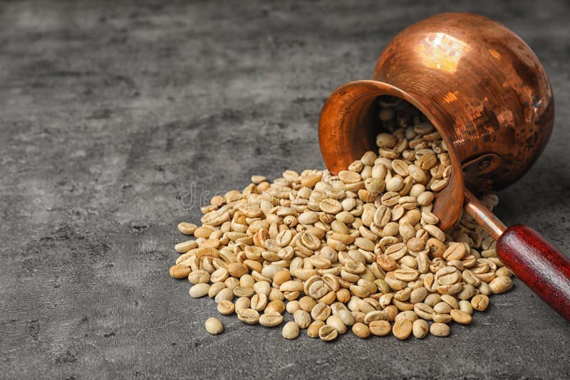 Jezve virada com grãos de café verde foto de stock royalty free