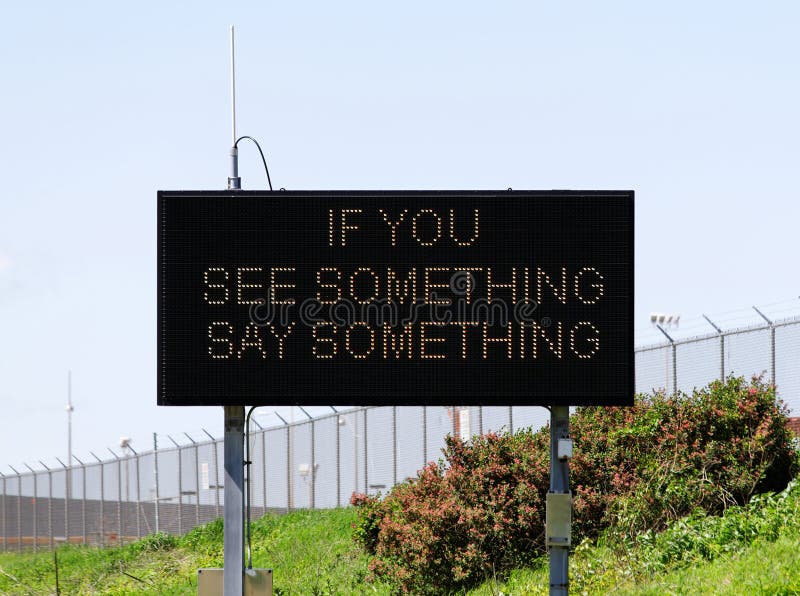 A sign near a major airport urges citizens to report suspicious activity. A sign near a major airport urges citizens to report suspicious activity.