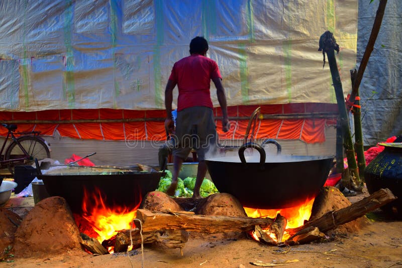 Jhargram, West-Bengalen, India - December 15,2018: Sommige mensen koken voedsel in een grote Steelpan voor het vieren van het huw royalty-vrije stock fotografie Jhargram, West-Bengalen, India - December 15,2018: Sommige mensen koken voedsel in een grote Steelpan voor het vieren van het huw royalty-vrije stock fotografie