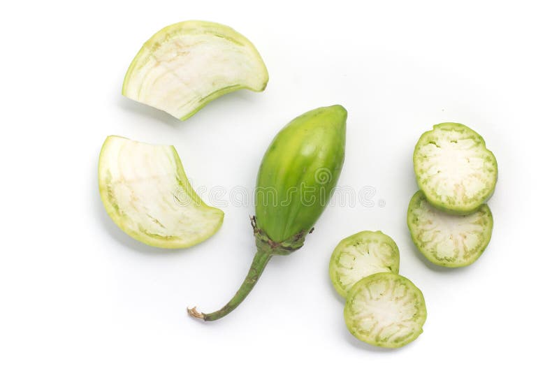 Lot of lot of vibrant green scarlet eggplant vegetable on top of each other  against a black background. Graphic minimalist image of food. Stock Photo