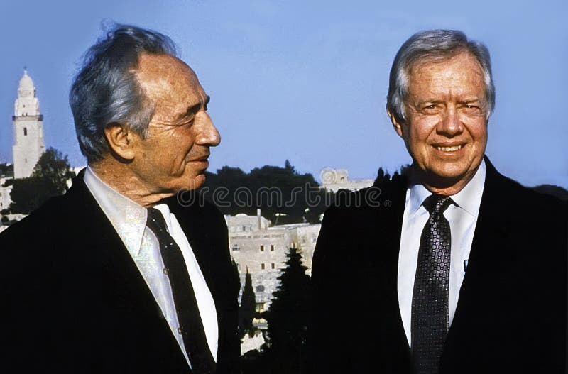 Jimmy Carter, 39th president of the United States visiting in Jerusalem, Israel in March, 1990, where he held meetings with Israeli and Arab officials trying to bridge the gaps between the two sides. Carter, a moderate Democrat, was president from 1977-1981. He led a remarkably active and constructive post-presidential life concerning himself with ameliorating global suffering, housing shortages and ravages from diseases as well as numerous peace seeking diplomatic missions. Born in Plains, Georgia on 1924, he became, on March 22, 2019, at age 94 the oldest living former president, eclipsing the age of George HW Bush. Here he is joined by then Israeli foreign minister Shimon Peres. Both men became Nobel Prize winners; March, 1990. Jimmy Carter, 39th president of the United States visiting in Jerusalem, Israel in March, 1990, where he held meetings with Israeli and Arab officials trying to bridge the gaps between the two sides. Carter, a moderate Democrat, was president from 1977-1981. He led a remarkably active and constructive post-presidential life concerning himself with ameliorating global suffering, housing shortages and ravages from diseases as well as numerous peace seeking diplomatic missions. Born in Plains, Georgia on 1924, he became, on March 22, 2019, at age 94 the oldest living former president, eclipsing the age of George HW Bush. Here he is joined by then Israeli foreign minister Shimon Peres. Both men became Nobel Prize winners; March, 1990.