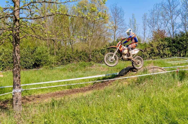 Jinete del motocrós en el salto del trampolín sobre el camino Concursos generales en motocrós en la provincia de Varese fotografía de archivo libre de regalías Jinete del motocrós en el salto del trampolín sobre el camino Concursos generales en motocrós en la provincia de Varese fotografía de archivo libre de regalías