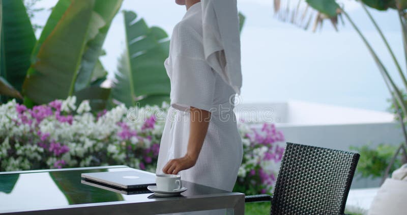 Job done female freelancer closes her laptop and goes to rest. female in bathrobe and towel on her head on terrace of stock video footage