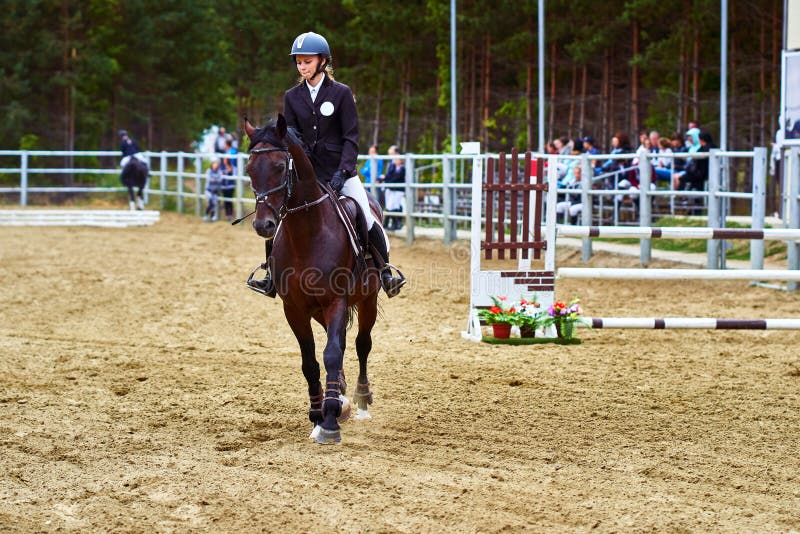 Jockey för ung kvinna i den vita svarta klänningen och svarta kängor fotografering för bildbyråer