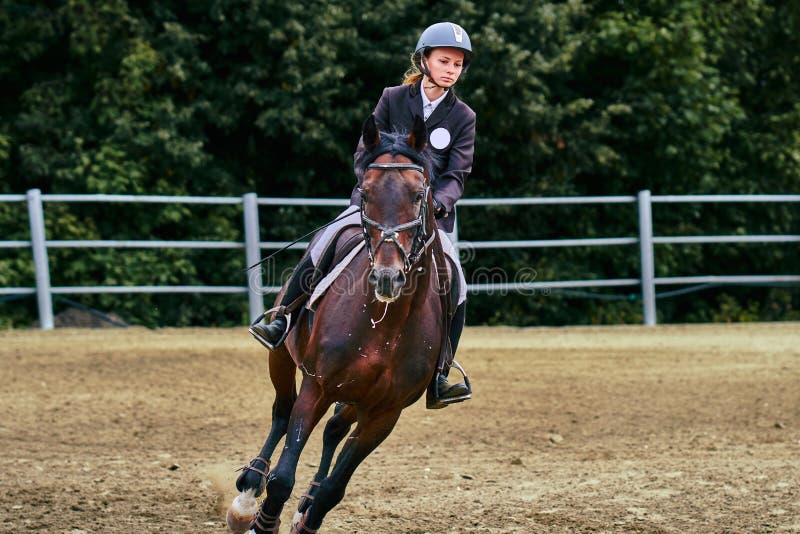 Jockey för ung kvinna i den vita svarta klänningen och svarta kängor royaltyfri fotografi