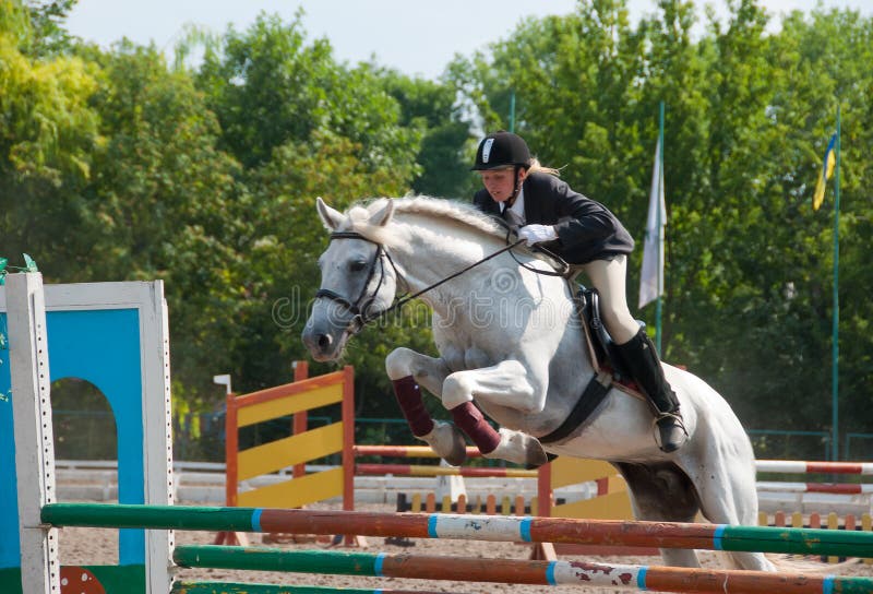 Jockey jumps over a hurdle at the competition