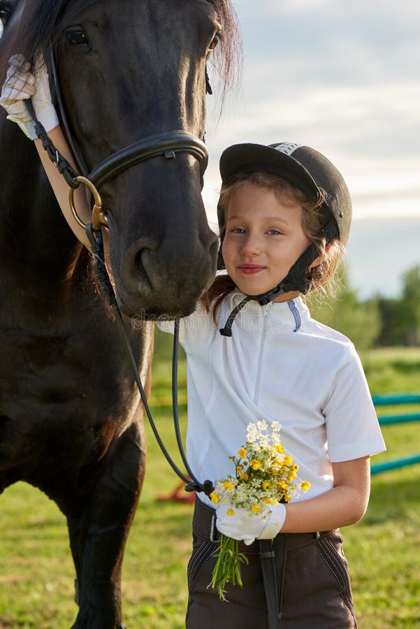 Jockey μικρών κοριτσιών που επικοινωνεί με τα άλογά της στην επαγγελματική εξάρτηση στοκ εικόνες Jockey μικρών κοριτσιών που επικοινωνεί με τα άλογά της στην επαγγελματική εξάρτηση στοκ εικόνες