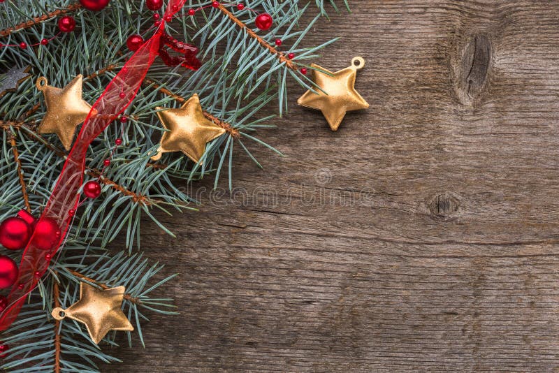 Fir branch with Christmas decorations on old wooden background with empty space for text. Top view. Fir branch with Christmas decorations on old wooden background with empty space for text. Top view.