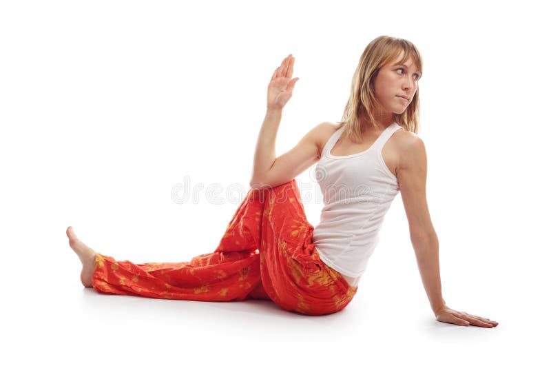 Young woman in red pants doing yoga exercises on a white. Young woman in red pants doing yoga exercises on a white