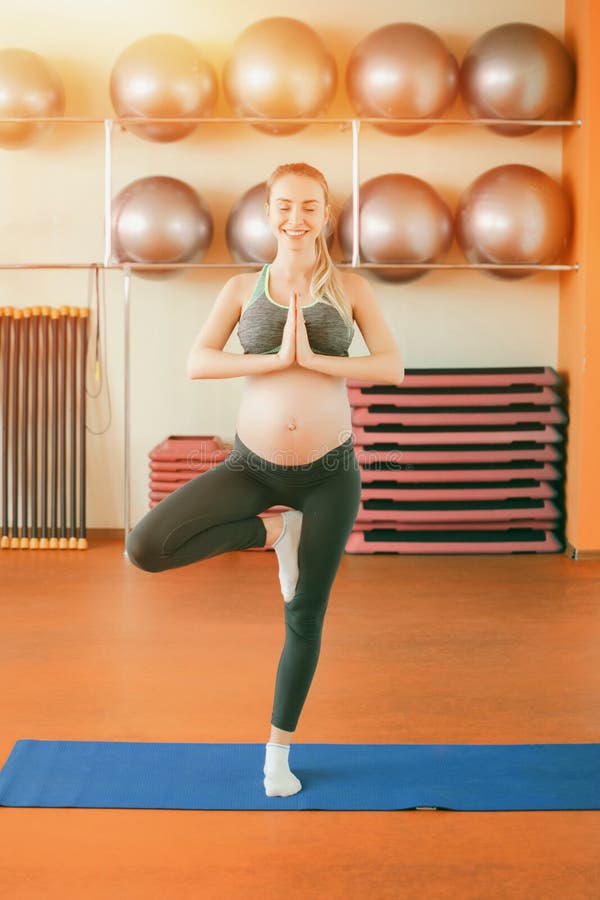 Joga dla kobieta w ciąży Młoda piękna ciężarna dziewczyny pozycja na jeden nodze fotografia stock Joga dla kobieta w ciąży Młoda piękna ciężarna dziewczyny pozycja na jeden nodze fotografia stock