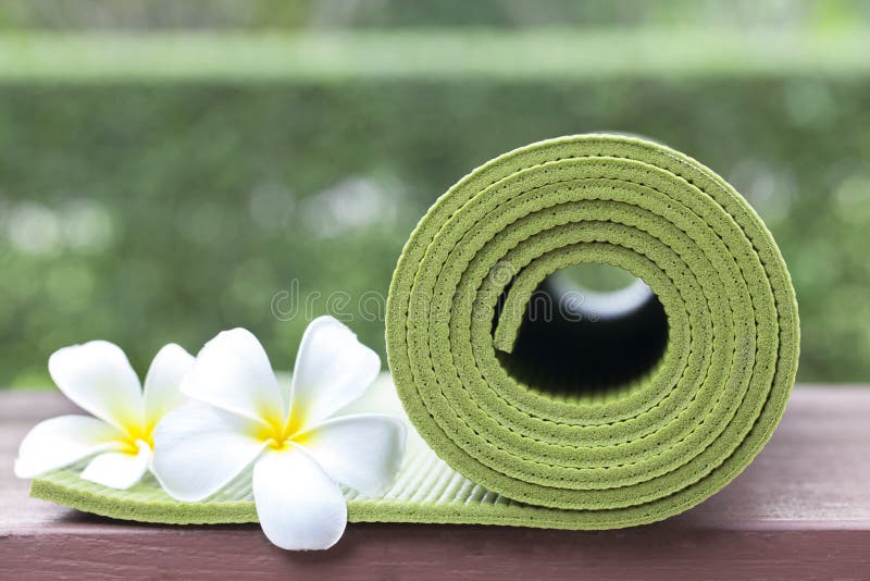 A green yoga mat and beautiful flowers. A green yoga mat and beautiful flowers