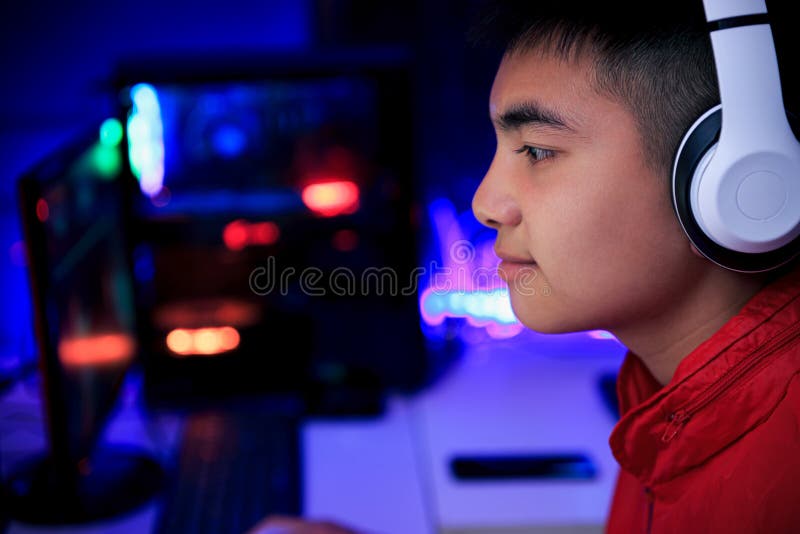 Jogador jogando jogo online no pc na sala escura.