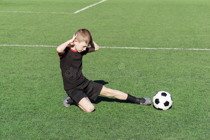 Um Jovem Jogador De Futebol Machucou Sua Perna Durante O Jogo E Bola No  Campo. Lesão Infantil No Conceito Desportivo. Cópia Foto de Stock - Imagem  de joelho, futebolista: 176890416