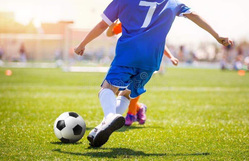 Jogador de futebol que retrocede a bola no passo da grama Grevista do futebol que marca o objetivo imagens de stock Jogador de futebol que retrocede a bola no passo da grama Grevista do futebol que marca o objetivo imagens de stock