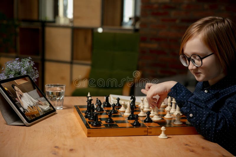 Menino Ruivo Nos óculos Sentado Em Casa E Jogando Xadrez Sozinho. Imagem de  Stock - Imagem de movimento, jogar: 208485515