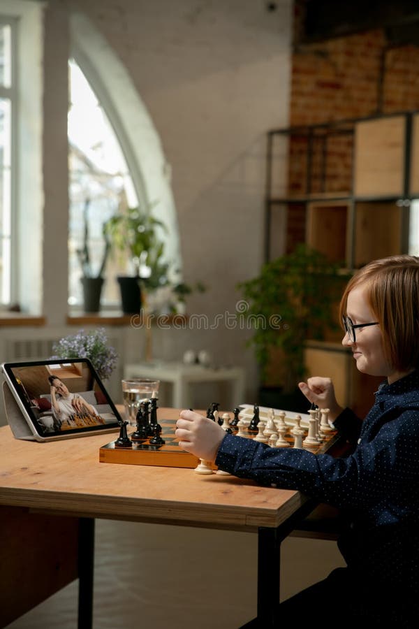 Mulher jogando xadrez online no laptop na mesa fechada